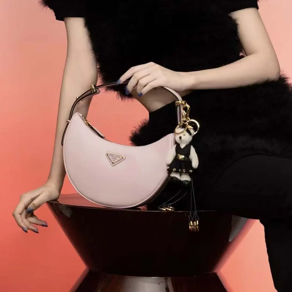 Side profile showing curved silhouette of Prada Women Arqué Mini Leather Shoulder Bag-Pink
