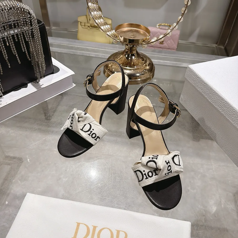 Close-up of J’Adior logo hardware and embroidered detail on sandal strap