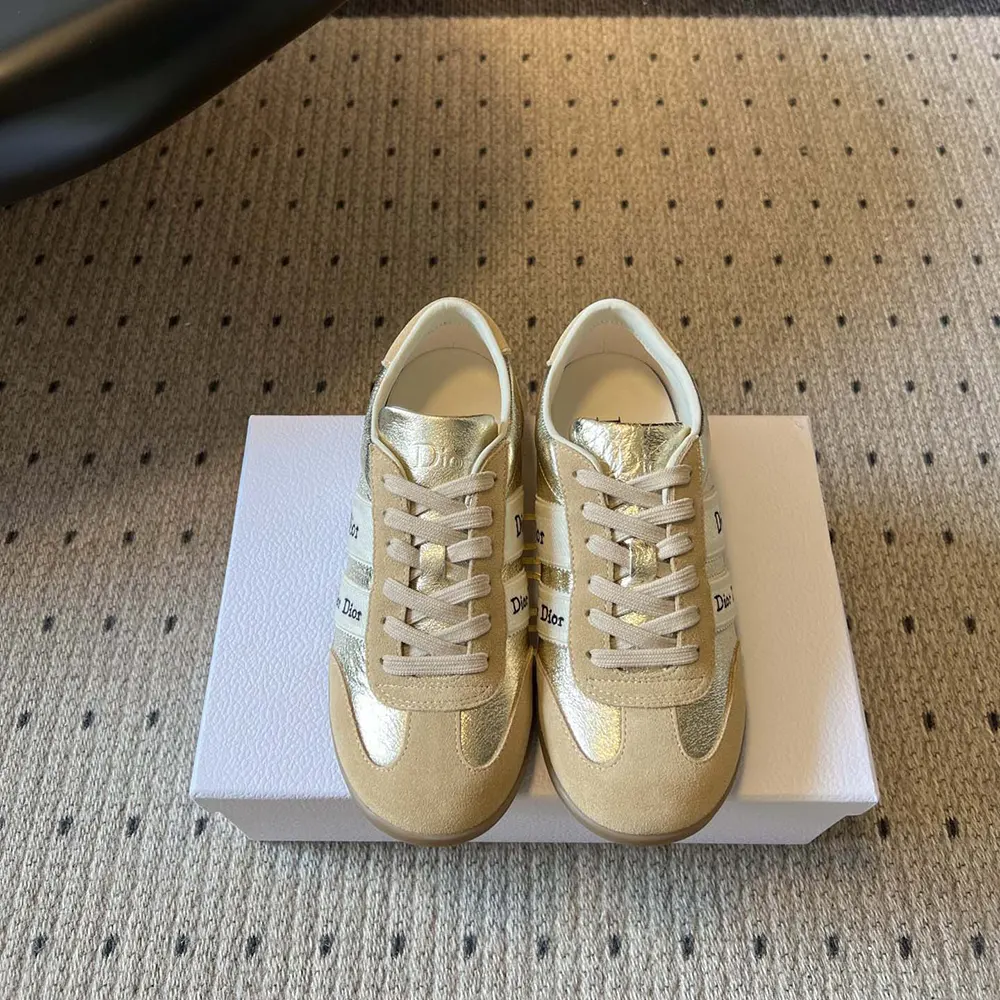 Top angle showing beige suede and signature gold hardware on Dior Women Ribbon Sneaker