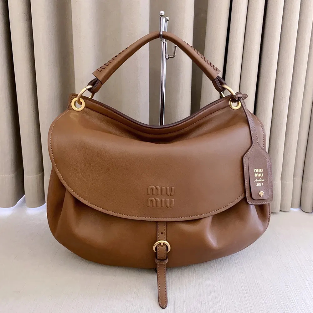 Close-up of gold-tone clasp and leather texture on Miu Miu Women Rendez-Vous Leather Bag Oak