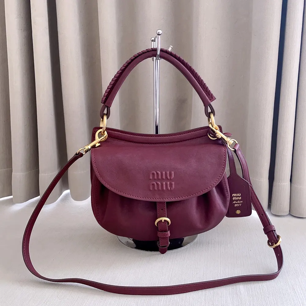 Side angle showing compact silhouette of Miu Miu Rendez-Vous leather bag