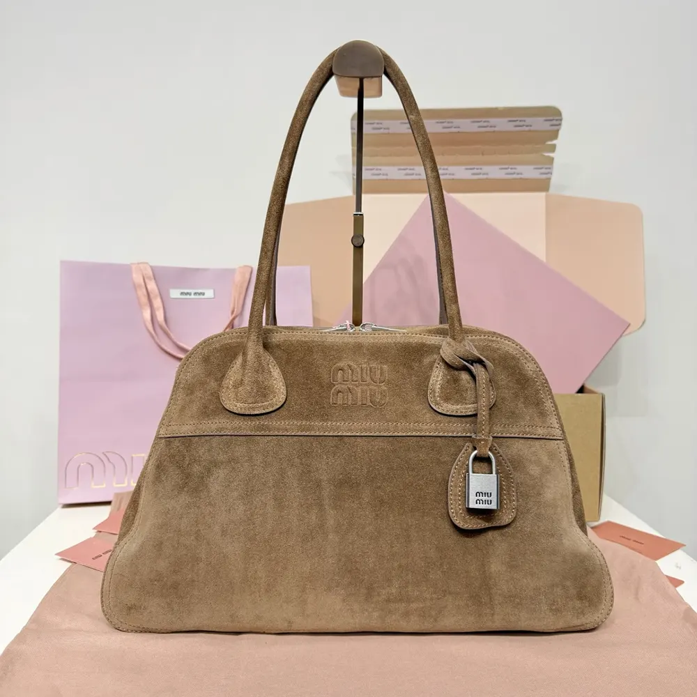 Close-up on gold-tone hardware and embossed logo on Miu Miu Vivant bag