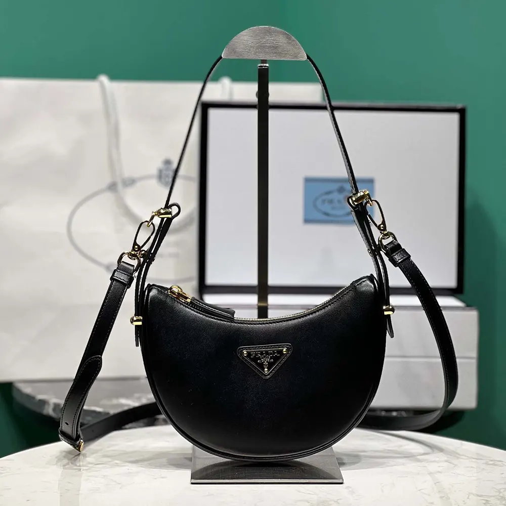 Close-up of Prada triangular logo on the Arqué Mini Leather Shoulder Bag