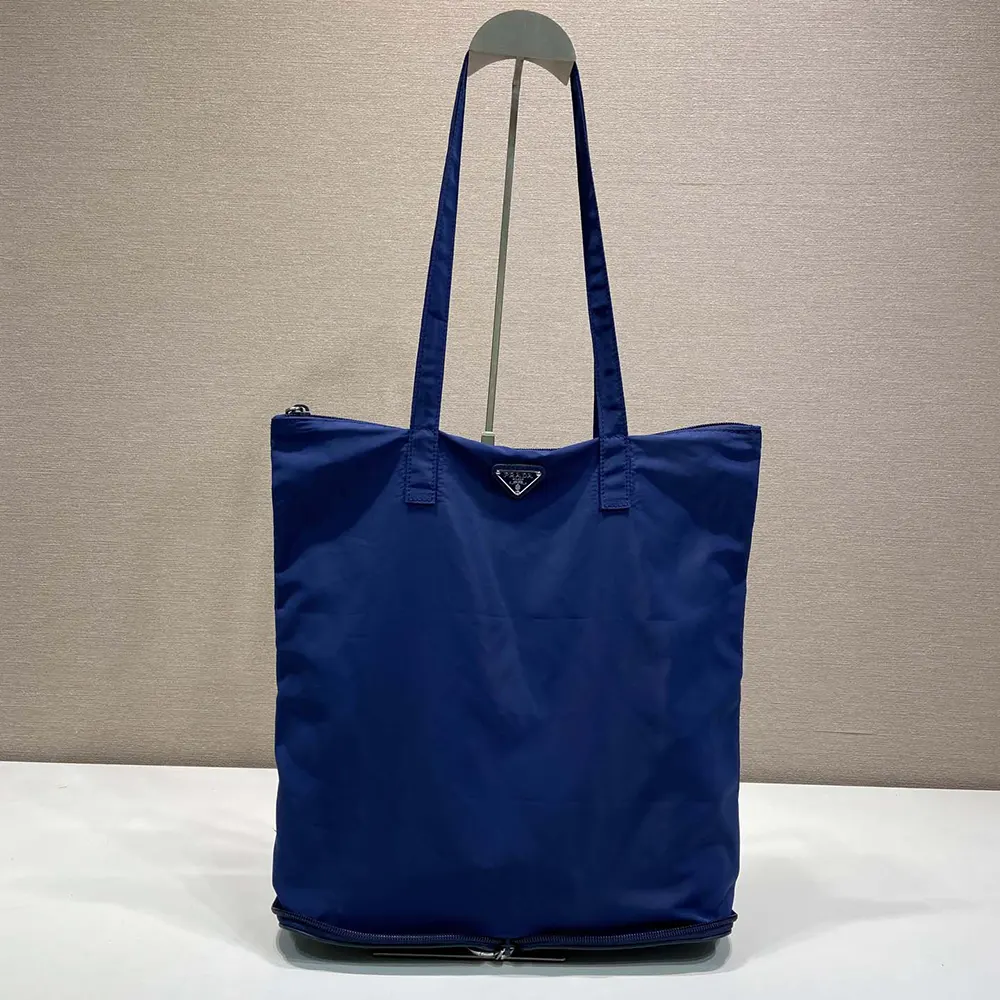 Side angle showing structured silhouette of Prada Women Saffiano Leather Pendant With Re-Nylon Tote Bag-Baltic Blue