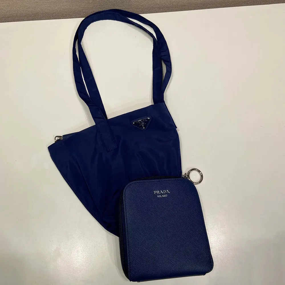 Close-up of silver-tone pendant and hardware on Prada Women Saffiano Leather Pendant With Re-Nylon Tote Bag-Baltic Blue