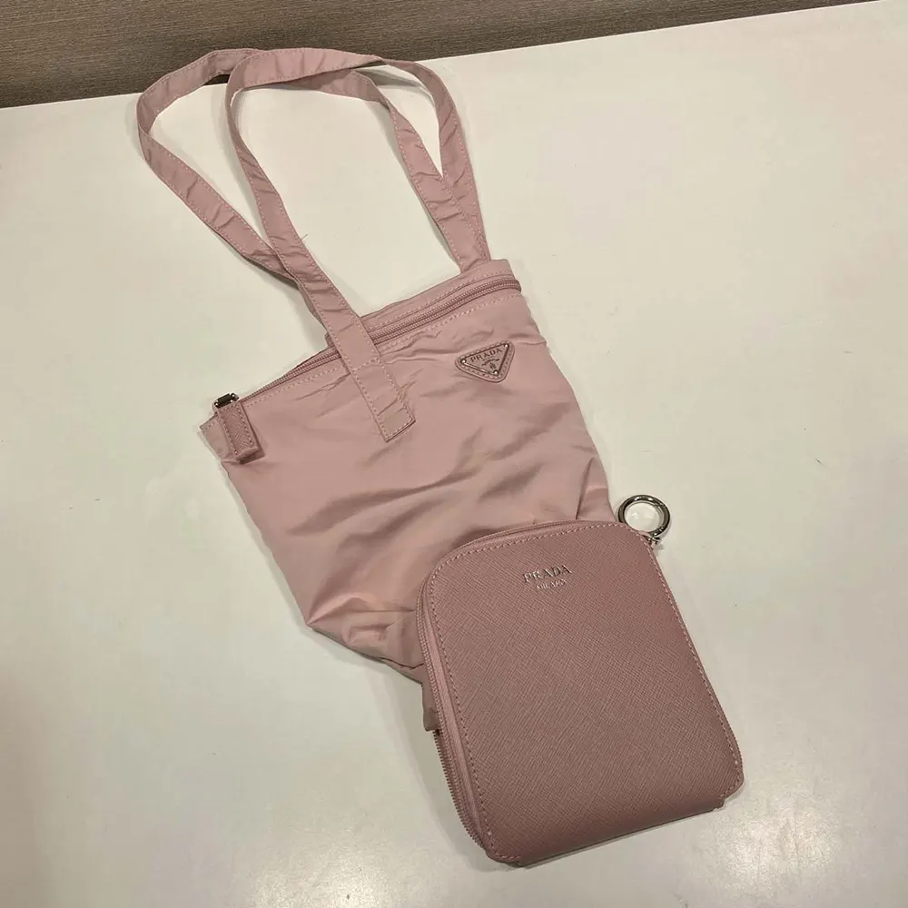 Close-up of peach Saffiano leather and gold-tone pendant on Prada tote bag