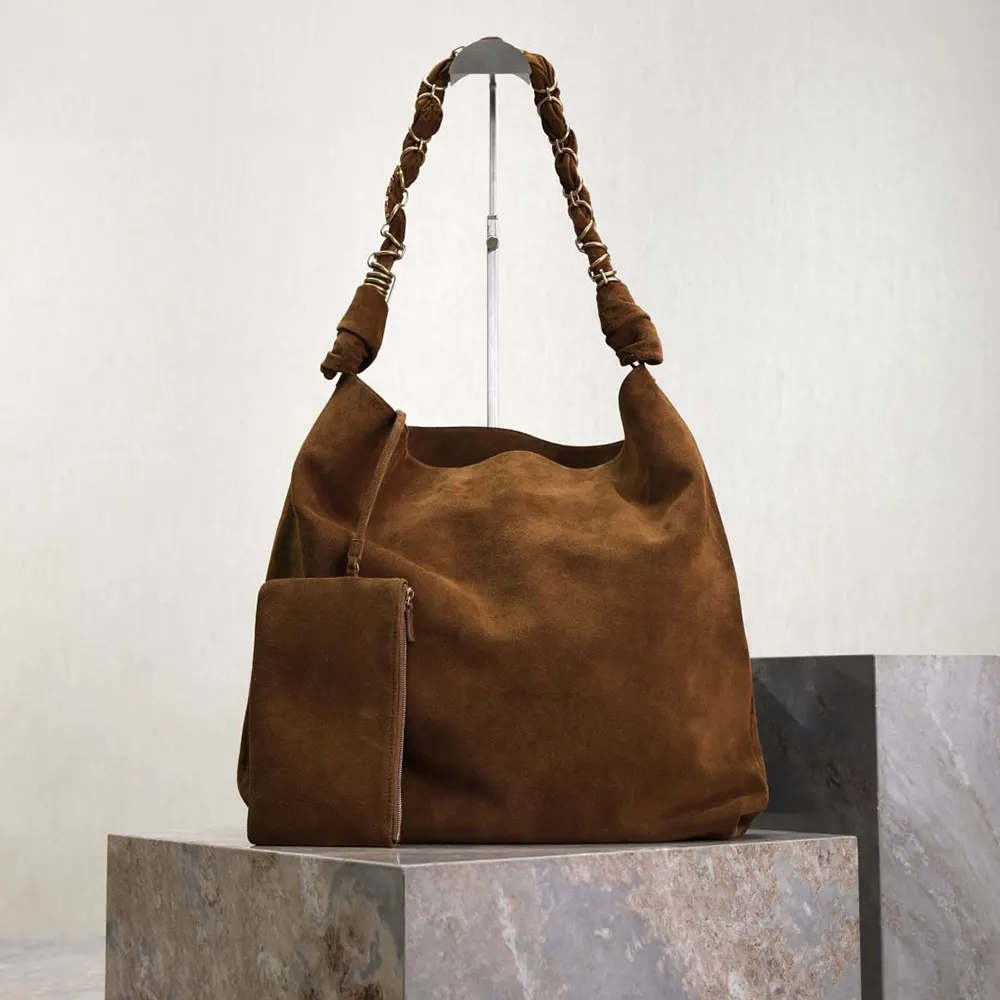 Close-up of antique gold YSL hardware on Saint Laurent Amalia suede bag