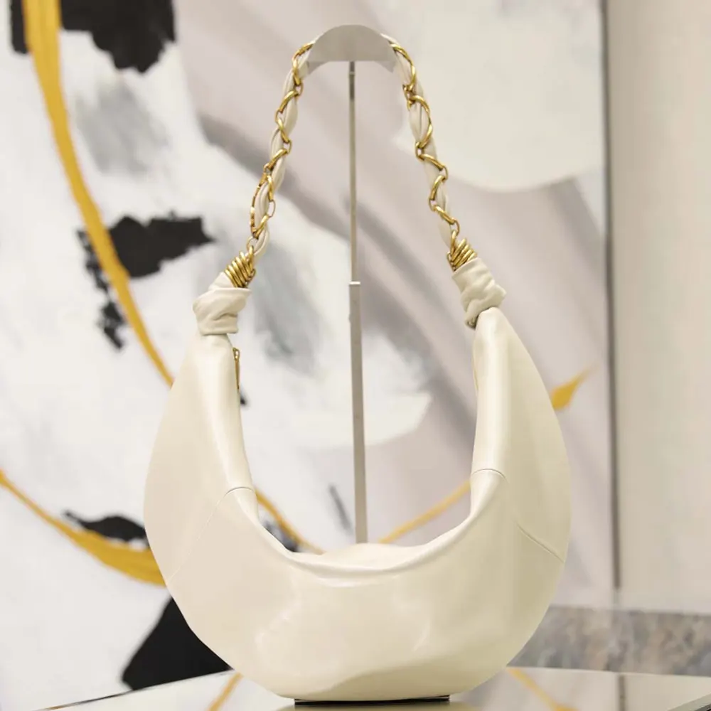 Close-up of gold YSL logo on white lambskin Amalia small hobo bag