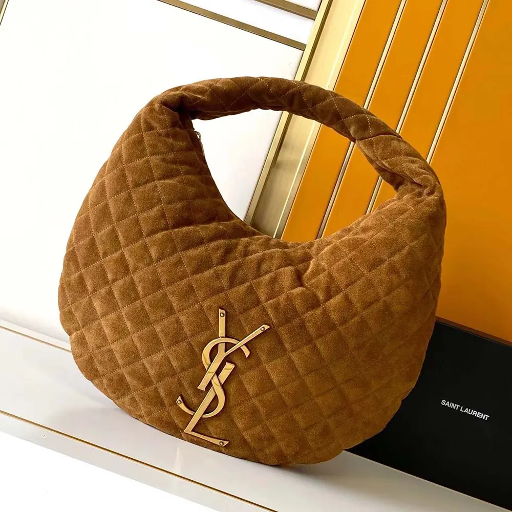 Close-up of gold YSL logo hardware on quilted suede bag