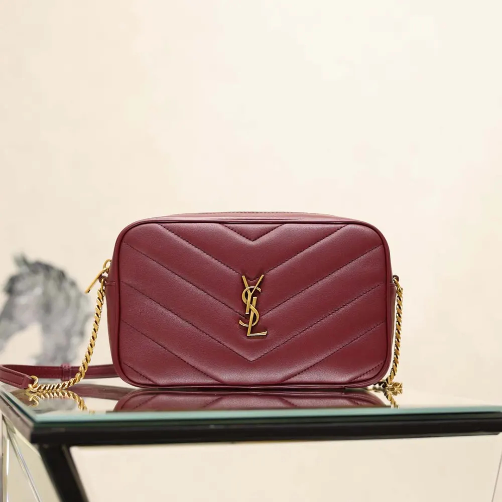 Close-up of gold YSL monogram on Loulou Camera Bag in Bordeaux lambskin