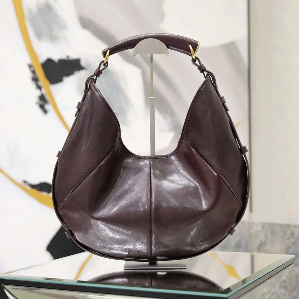 Close-up of gold YSL hardware on Mombasa Medium Bordeaux leather bag