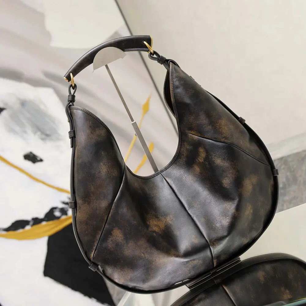 Close-up of gold YSL logo hardware on vintage leather bag