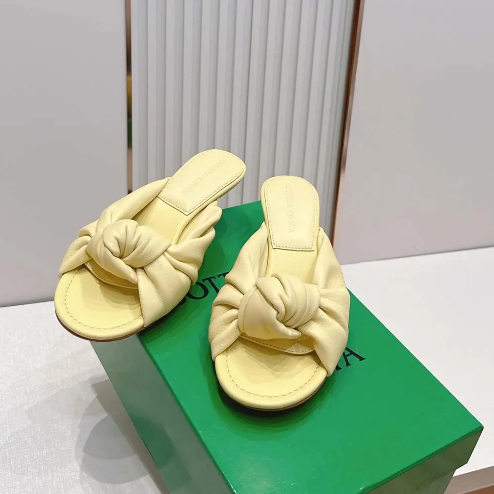 Close-up detail of knotted nappa leather on yellow flat slide sandal