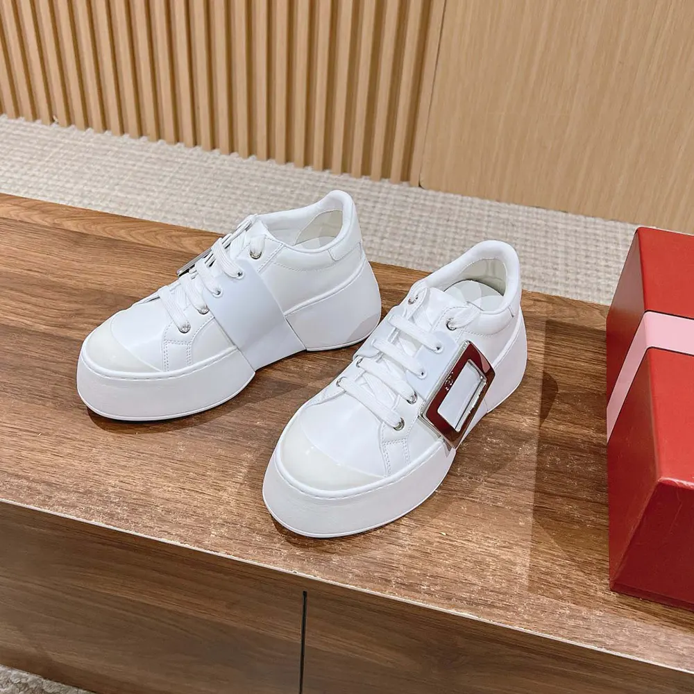 Close-up of white leather and Viv’ buckle detail on sneakers