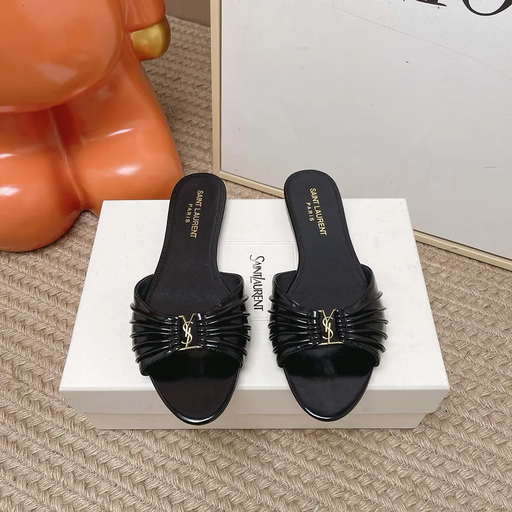 Close-up detail of gold YSL logo on Babylone Slides in black