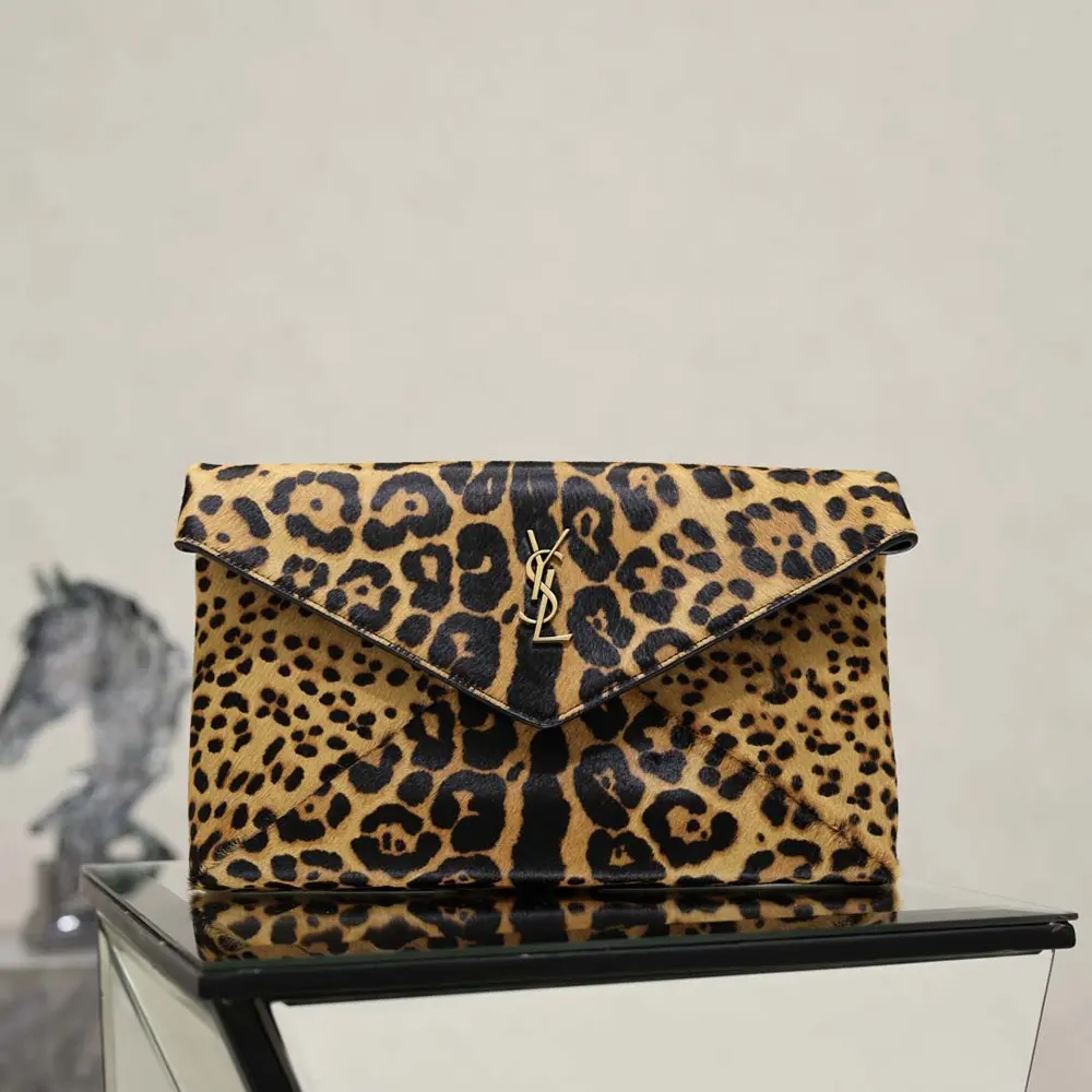 Close-up of gold YSL logo hardware on Cassandre Large Envelope Pouch