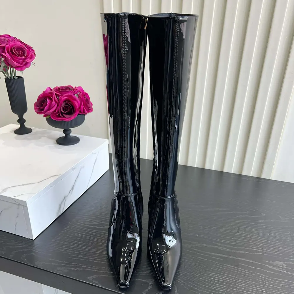 Close-up of gold YSL logo hardware on black leather Francoise boots